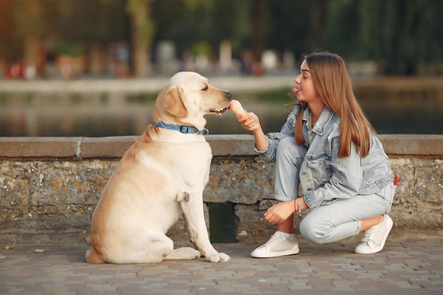 Chica caminando en una ciudad de primavera con lindo perro