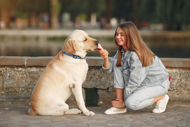 Chica caminando en una ciudad de primavera con lindo perro