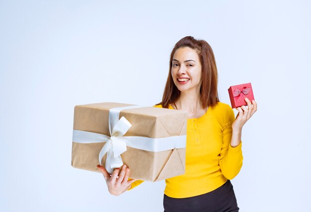 Chica de camisa amarilla con cajas de regalo.