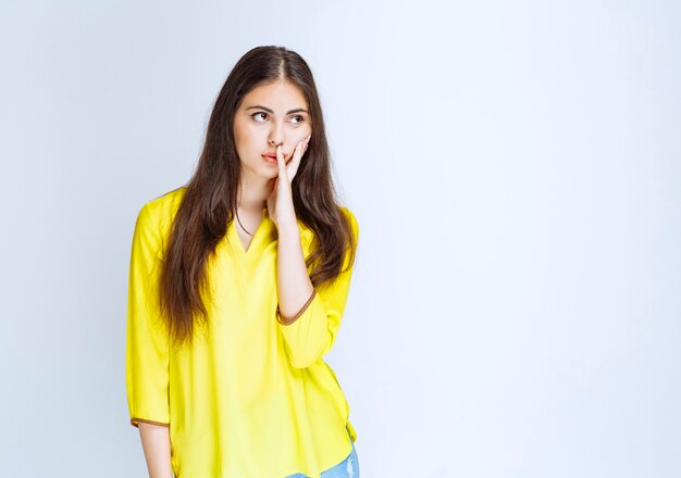 La chica con camisa amarilla se ve aterrorizada y emocionada.