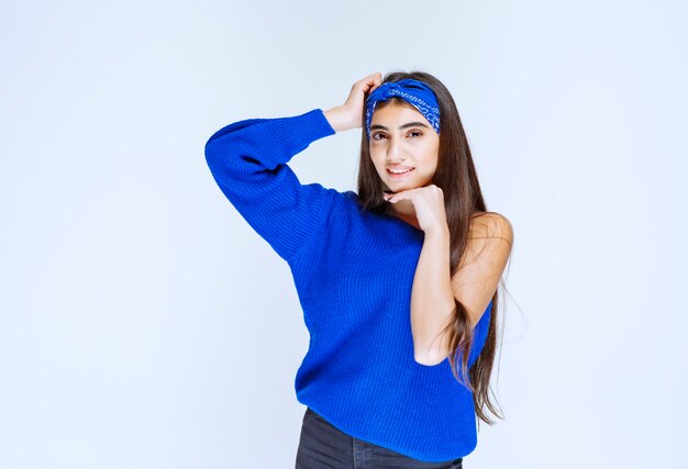 Chica en camisa azul dando poses seductoras y alegres.