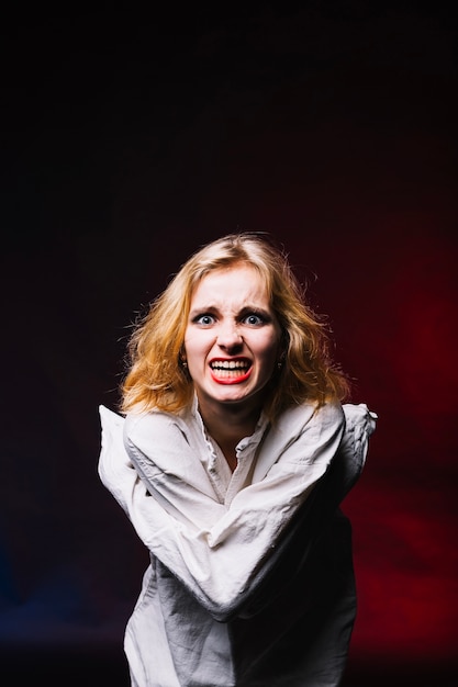 Foto gratuita chica en camisa de fuerza sonriendo a la cámara