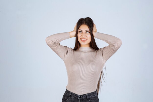 Chica en camisa gris dando poses atractivas y seductoras.