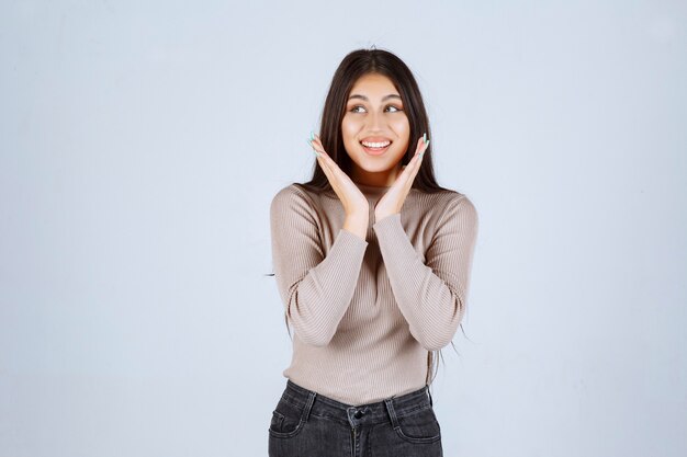 Chica en camisa gris dando poses atractivas y seductoras.