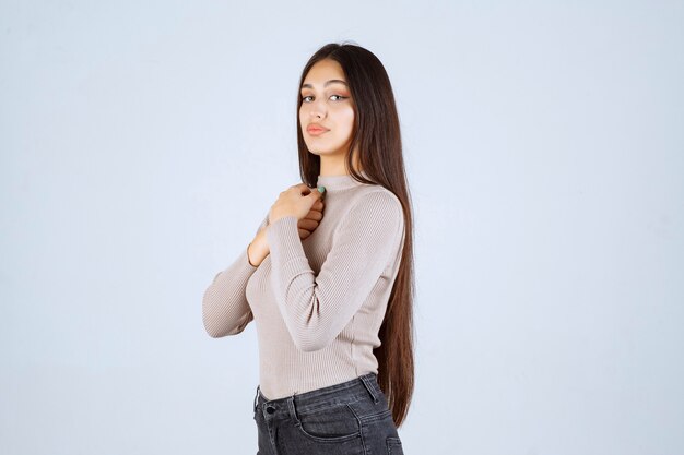 Chica en camisa gris dando poses atractivas y seductoras.