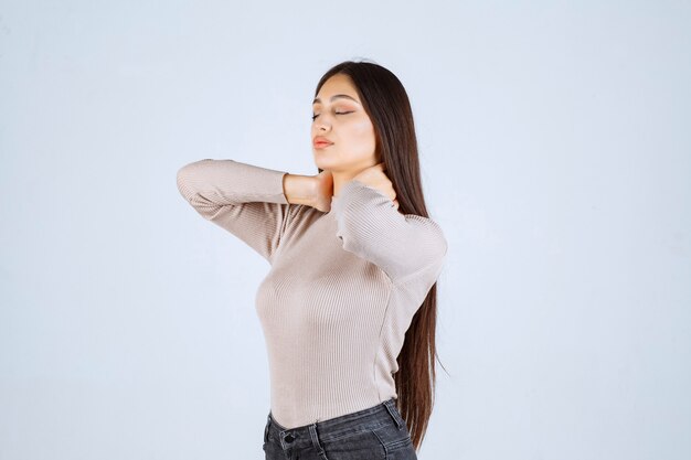 Chica en camisa gris dando poses atractivas y seductoras.