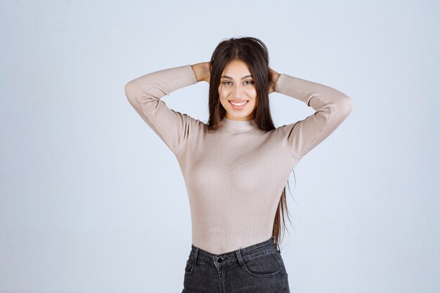 Chica en camisa gris dando poses positivas y atractivas.