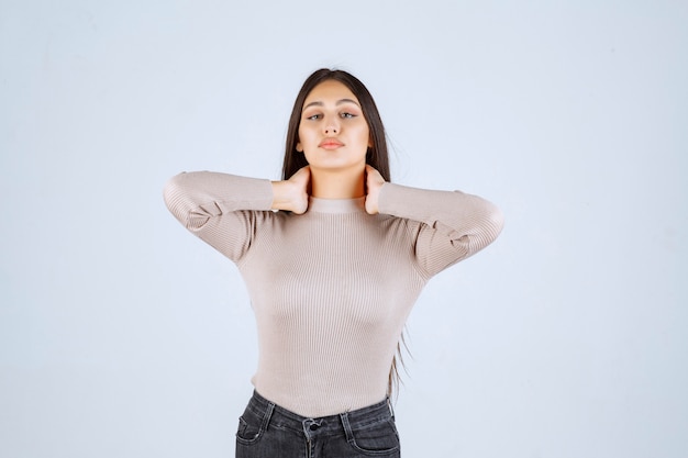 Chica en camisa gris dando poses positivas y atractivas.