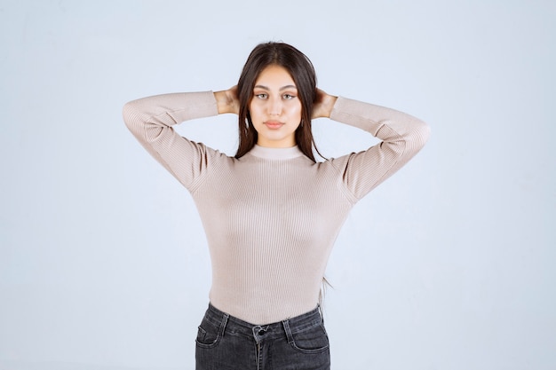 Chica en camisa gris dando poses positivas y atractivas.