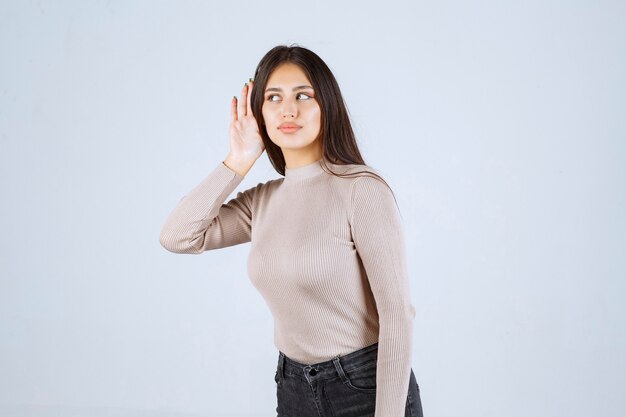 Chica de camisa gris escuchando atentamente.