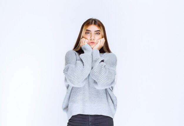 La chica con una camisa gris parece aterrorizada y asustada.