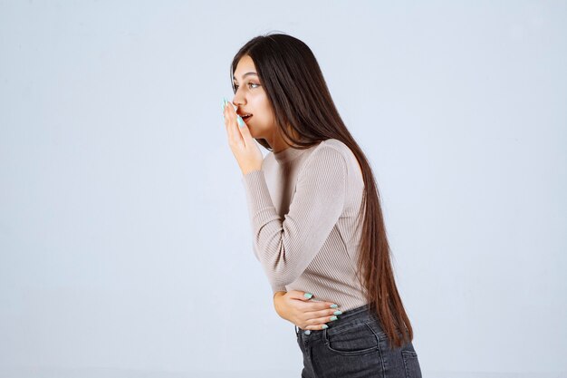 La chica con camisa gris se ve emocionada y sorprendida.