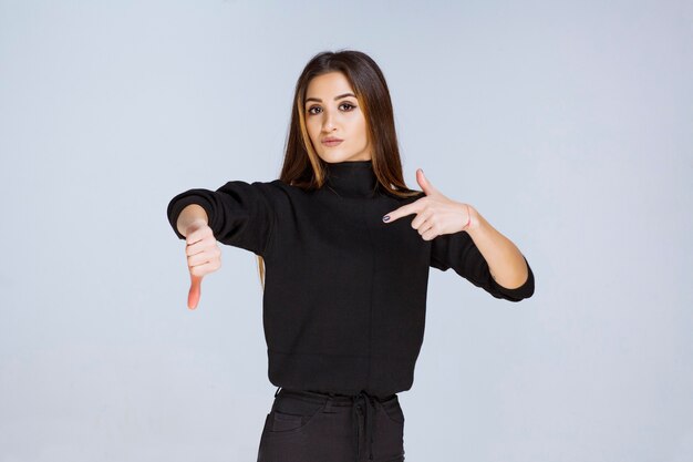 Chica en camisa negra comprobando su tiempo. Foto de alta calidad