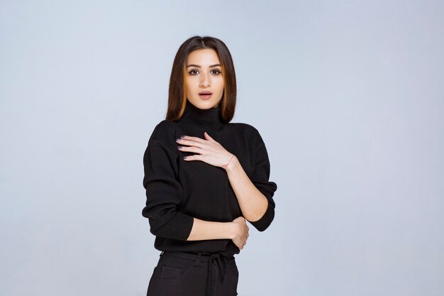 Chica en camisa negra dando poses atractivas para la foto de portada de las redes sociales. Foto de alta calidad