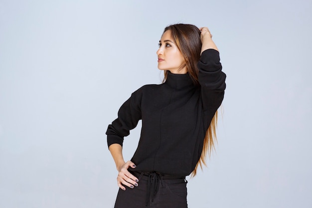 Chica en camisa negra dando poses atractivas para la foto de portada de las redes sociales. Foto de alta calidad