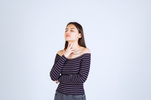 Chica en camisa a rayas dando poses neutrales sin reacciones.