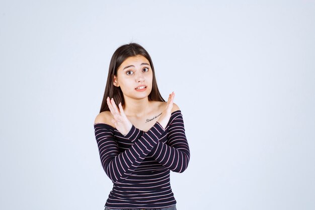 Chica en camisa a rayas parando y previniendo algo.