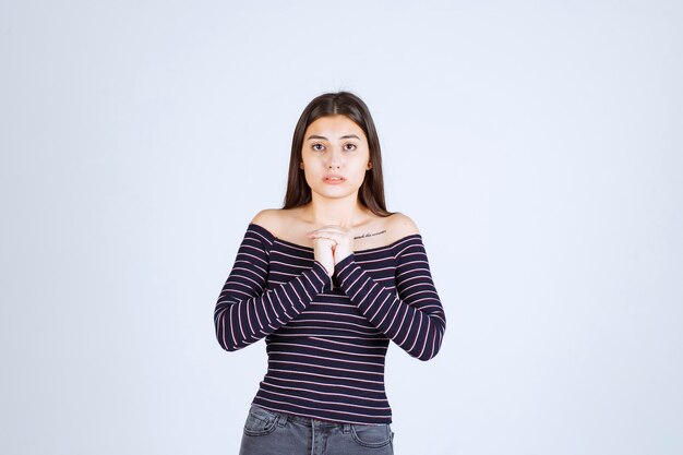 Chica con camisa a rayas parece aterrorizada y asustada.