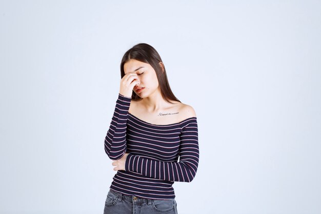 Chica en camisa a rayas pensando y analizando.