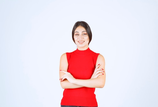 Chica en camisa roja dando poses encantadoras y seductoras.