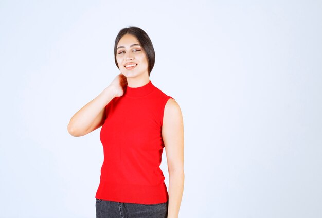 Chica en camisa roja dando poses encantadoras y seductoras.