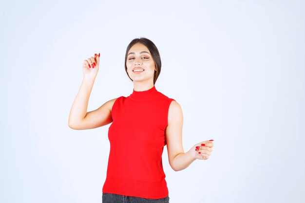 Chica en camisa roja dando poses neutrales, positivas y atractivas.