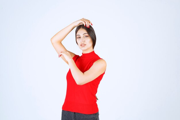 Chica en camisa roja dando poses neutrales, positivas y atractivas.