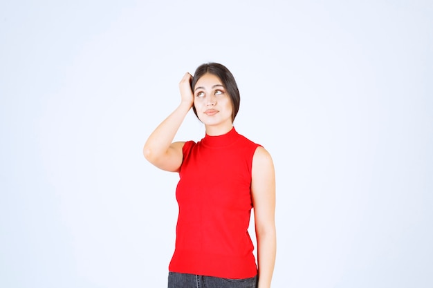 Chica en camisa roja dando poses neutrales, positivas y atractivas.