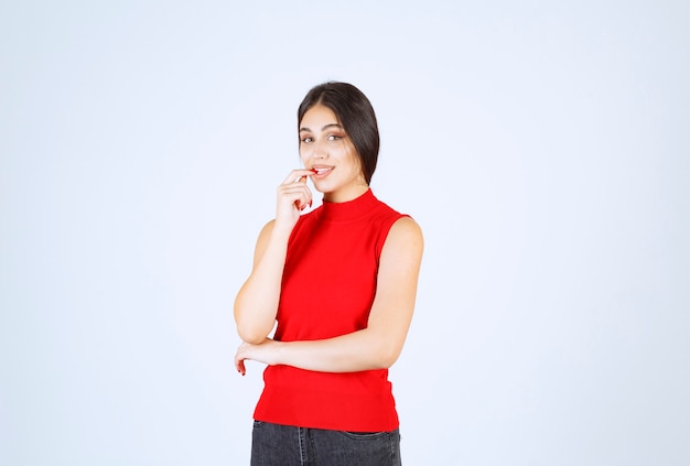 Chica en camisa roja dando poses neutrales, positivas y atractivas.