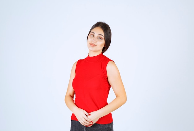 Chica en camisa roja dando poses neutrales, positivas y atractivas.