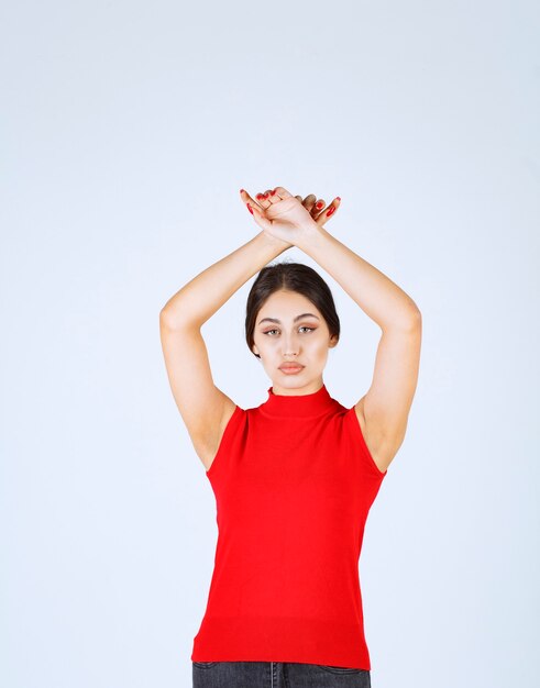 Chica en camisa roja dando poses neutrales, positivas y atractivas.