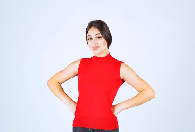 Chica en camisa roja dando poses neutrales, positivas y atractivas.