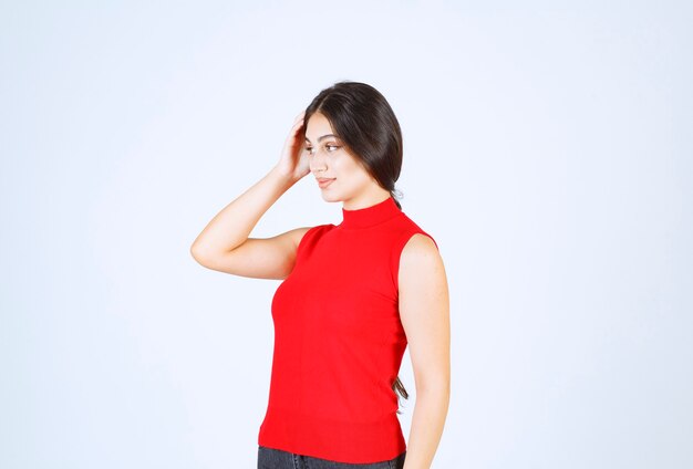 Chica con una camisa roja dando poses positivas y seductoras.