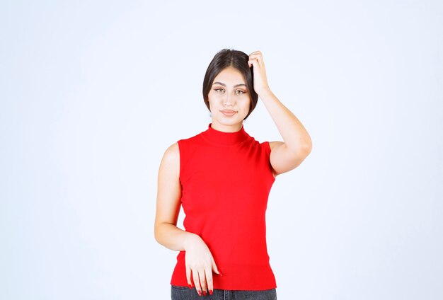 Chica con una camisa roja dando poses positivas y seductoras.