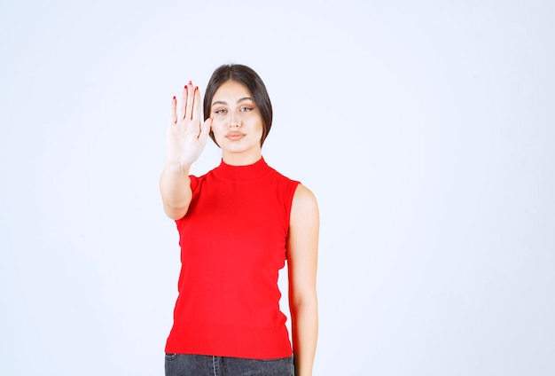 Chica de camisa roja impidiéndose algo.