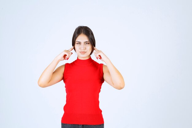 Chica de camisa roja pensando y analizando.