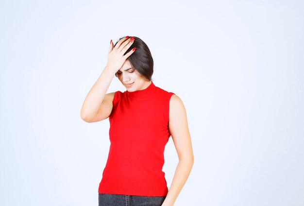 La chica de camisa roja se ve estresada y nerviosa.