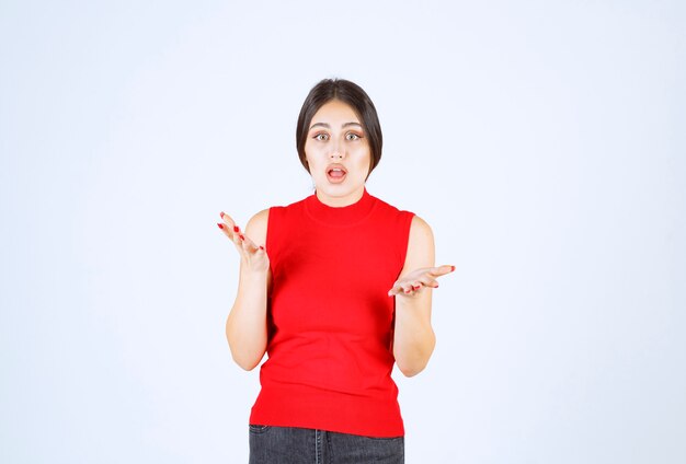 La chica de camisa roja se ve estresada y nerviosa.