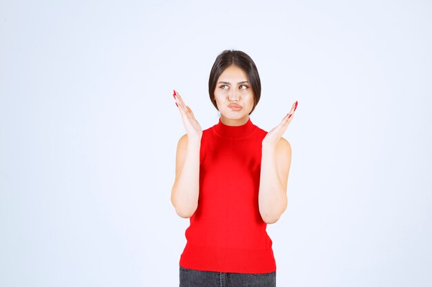 La chica de camisa roja se ve estresada y nerviosa.