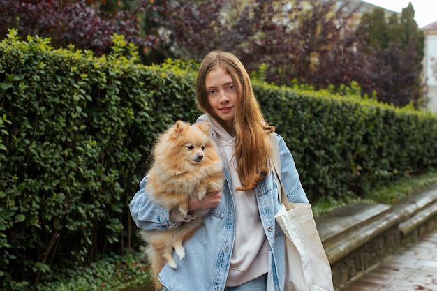 Chica cargando bolsa con perro plano medio