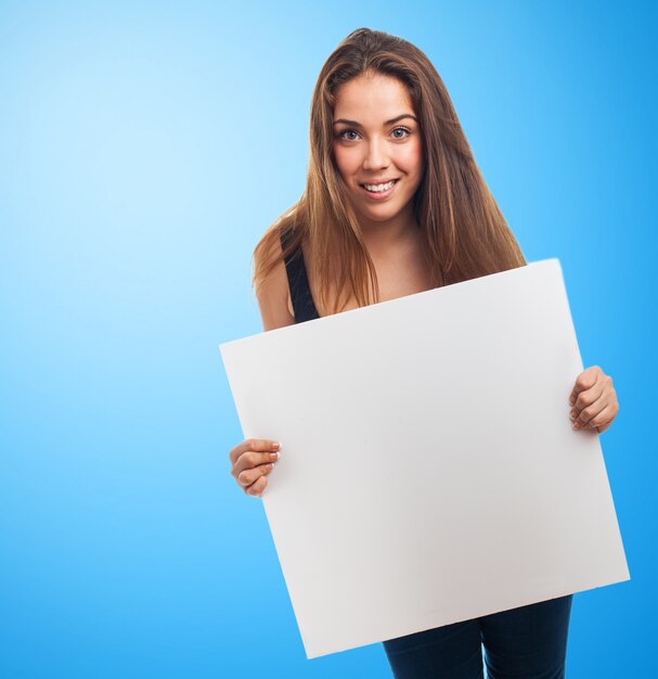 Chica con un cartel en un fondo azul