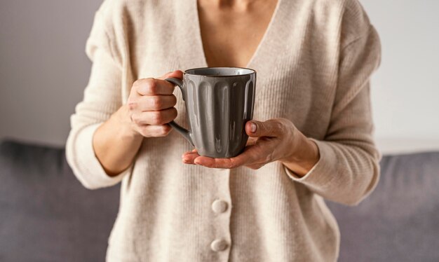 Chica en casa con taza de té