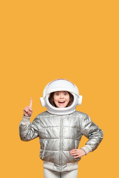 Chica con casco espacial señalando