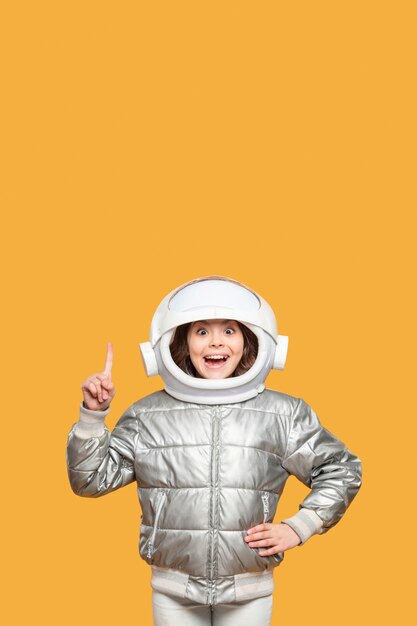 Chica con casco espacial señalando