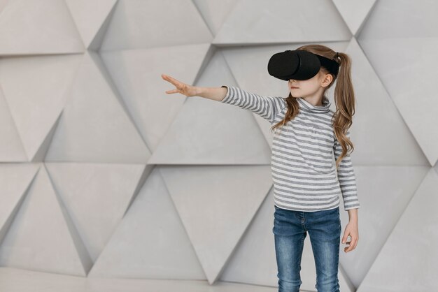 Chica con casco de realidad virtual y estirando su mano