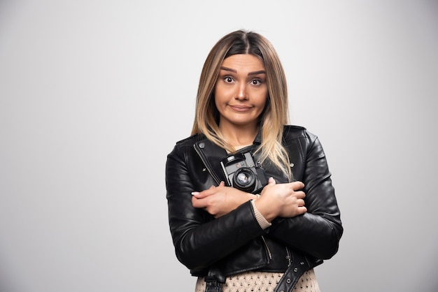 Chica con chaqueta de cuero tomando sus fotos en posiciones divertidas y extrañas.