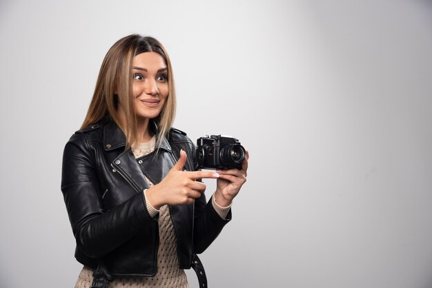 Chica con chaqueta de cuero tomando sus fotos en posiciones divertidas y extrañas