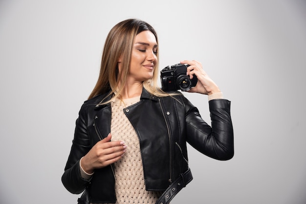 Chica con chaqueta de cuero tomando sus fotos en posiciones elegantes y positivas