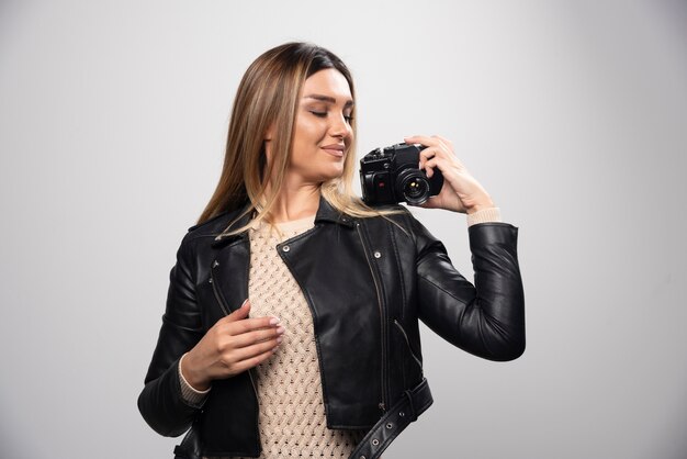 Chica con chaqueta de cuero tomando sus fotos en posiciones elegantes y positivas