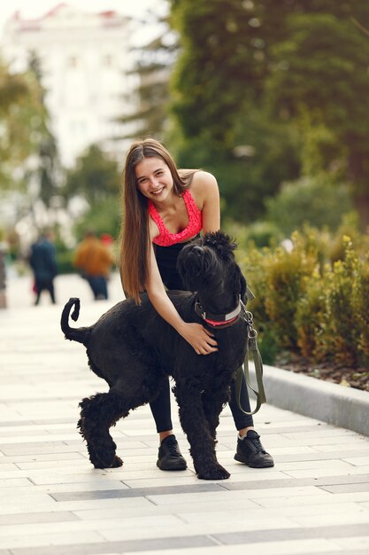 Chica en una ciudad de verano con perro